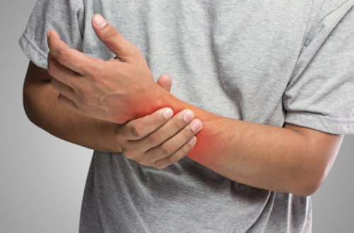 A man holding his wrist in pain | Chiropractor near me